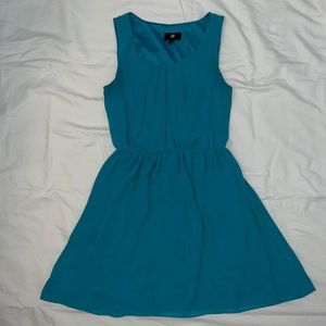 Sleeveless teal dress with front detail.